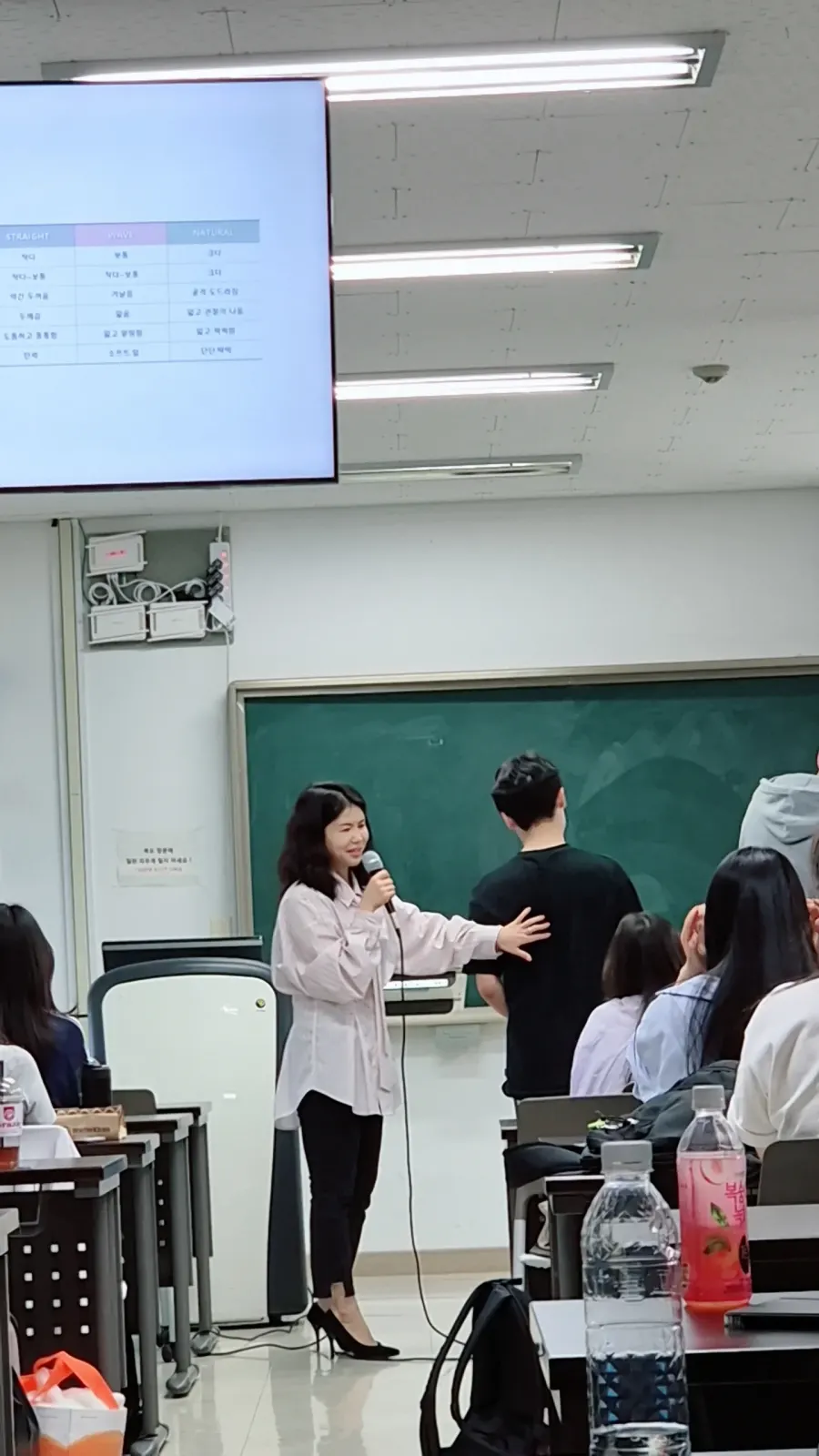 학교 강의실 칠판 앞에서 학생과 함께 진로체험 프로그램을 진행하는 모습